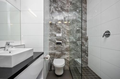 a bathroom with a toilet and a sink and a shower at Gardens Centre Holiday Apartments in Cape Town