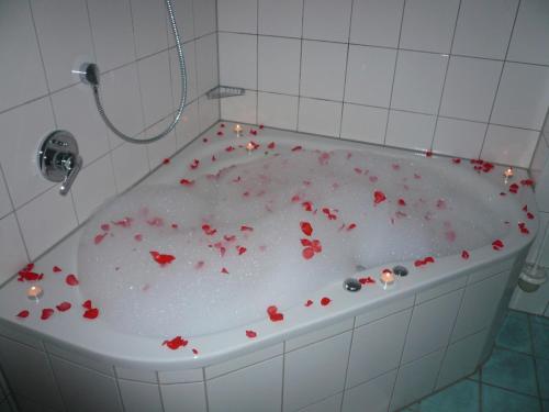 una bañera con corazones rojos. en Meister BÄR HOTEL Bayreuth, en Goldkronach