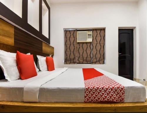 a bedroom with a bed with red and white pillows at Hotel Bansal Residency, Sirsa in Sirsa