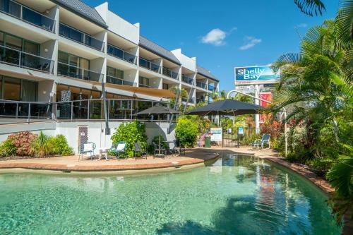 a swimming pool in front of a hotel at Shelly Bay Resort in Hervey Bay