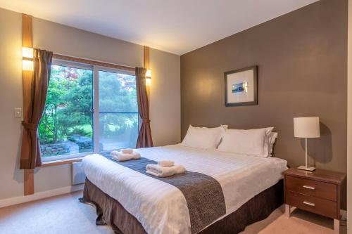 ein Schlafzimmer mit einem großen Bett mit zwei Handtüchern darauf in der Unterkunft Parkside Chalet Furano in Furano