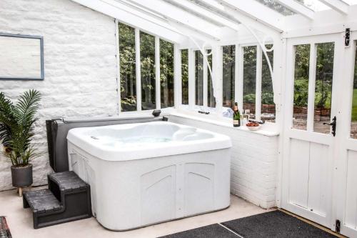 a white bath tub in a room with windows at Redmayne House in Lake District National Park