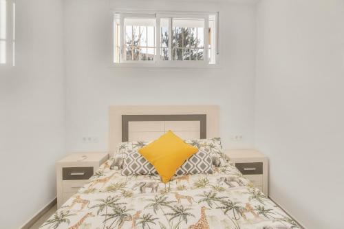Dormitorio con cama con almohada amarilla en MILLION APARTAMENT en Málaga