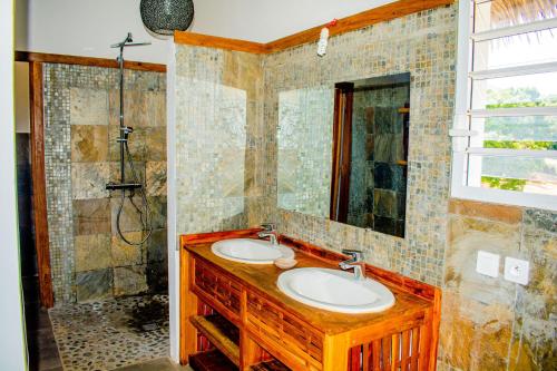 a bathroom with two sinks and a shower at Tiako Villas in Ambondrona