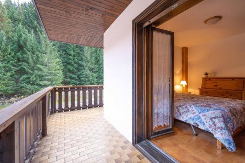 a bedroom with a bed on a balcony at Cesa Alpes 3 in Campitello di Fassa