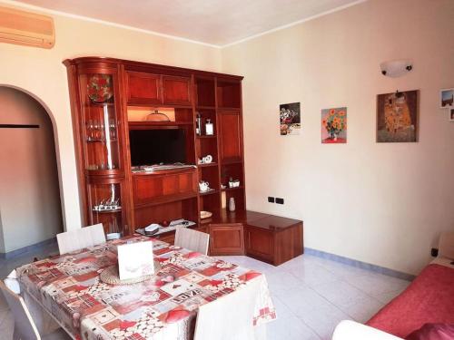 een woonkamer met een eettafel en een televisie bij Casa vacanze “da Mara” in Rho