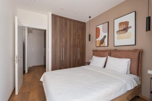 1 dormitorio con 1 cama grande con sábanas blancas en Downtown Luxury Apartment #2, en Ioannina