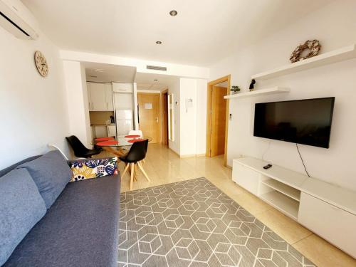 sala de estar con TV de pantalla plana en la pared en Apartament Lloret de Mar with terrace en Lloret de Mar