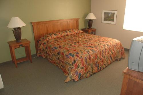 a hotel room with a bed and two night stands at Powder Ridge Village, a VRI resort in Powder Mountain West