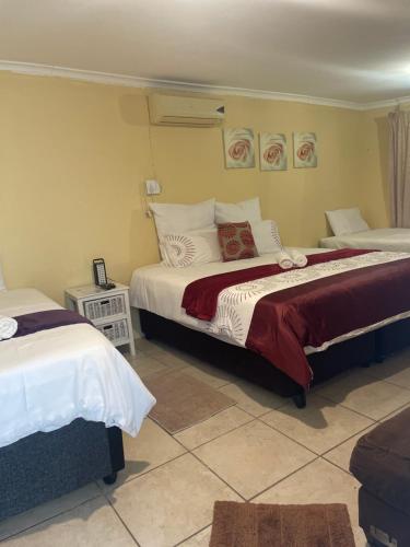 a bedroom with two beds with red and white sheets at Fj's place in Durban