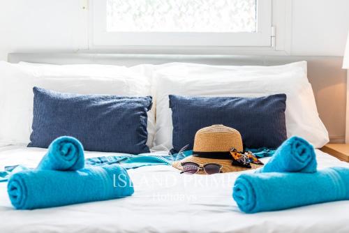 a bed with a hat and glasses and blue pillows at 4x Bedrooms Poolside Apartment in Amarilla Golf in San Miguel de Abona