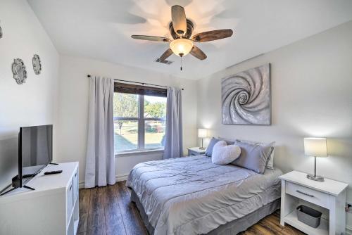 a bedroom with a bed and a ceiling fan at Claremore Getaway about 2 Mi to Historic District in Claremore