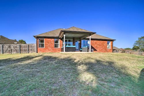 a brick house with a fence in a yard at Claremore Getaway about 2 Mi to Historic District in Claremore