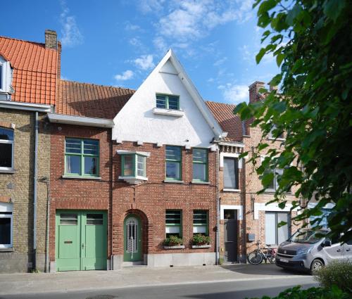 a red brick house with a white roof at Rûte - Bed no Breakfast in Bruges