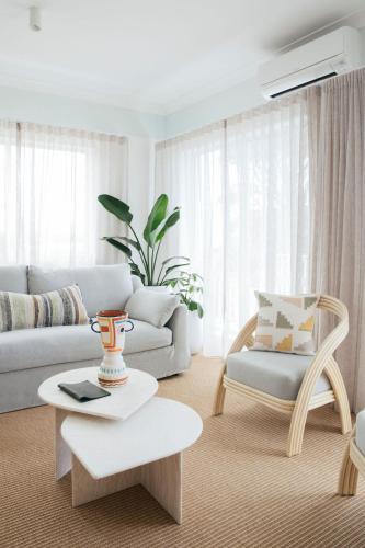a living room with a couch and a table at Motel Molly - Boutique Hotel Mollymook in Mollymook