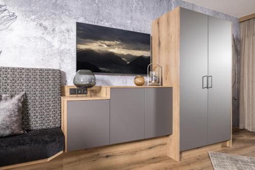 a living room with a desk and a couch at Hotel Viktoria & Landhaus Joggl in Mayrhofen