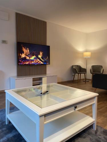 a glass table in a living room with a tv at Ferienwohnung auf dem Sonnenhang in Bad Rothenfelde