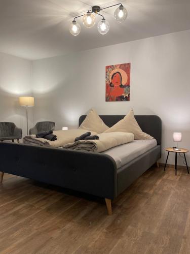 a large bed in a room with two chairs at Ferienwohnung auf dem Sonnenhang in Bad Rothenfelde