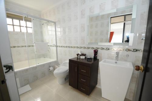 een badkamer met een toilet, een douche en een wastafel bij Villeta Boutique Hotel Spa in Villeta