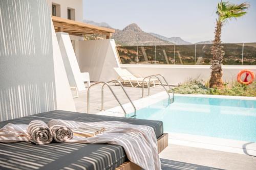 a bed sitting next to a swimming pool at Kakkos Bay Hotel and Bungalows in Ierápetra