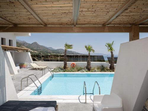 uma vista para uma piscina com palmeiras em Kakkos Bay Hotel and Bungalows em Lerápetra