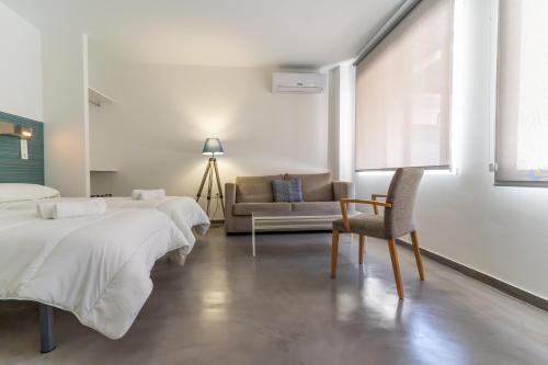 a bedroom with two beds and a chair and a couch at Albergue Inturjoven Cazorla in Cazorla