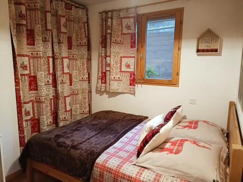 a bedroom with a bed and a window at Appartement avec terrasse et parking Privé in Aigueblanche