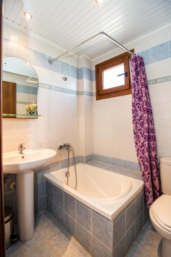 a bathroom with a tub and a sink and a toilet at STUDIOS NIKOS in Limenaria