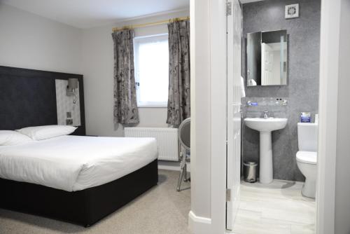 a bedroom with a bed and a sink and a toilet at Hibernian Hotel & Leisure Centre in Mallow