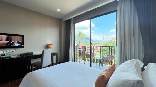 a hotel room with a bed and a window with a view at Amari Vang Vieng in Vang Vieng