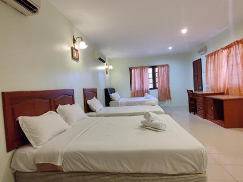 Dos camas en una habitación de hotel con dos camas. en Tekoma Resort Taman Negara, en Kuala Tahan