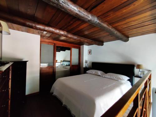 una camera con letto bianco e soffitti in legno di S.Giuseppe House a Pozzuoli