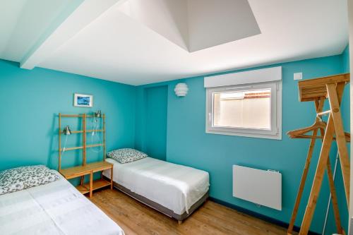 ein blaues Zimmer mit 2 Betten und einer Leiter in der Unterkunft Aux Bains des Mots - vue mer in Saint-Aubin-sur-Mer