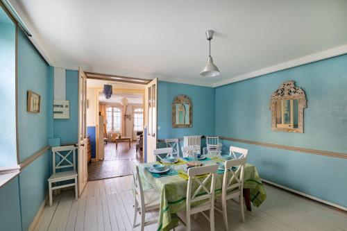 une salle à manger avec des murs bleus et une table et des chaises dans l'établissement Gîte de la tour, à Saint-Aubin-sur-Mer