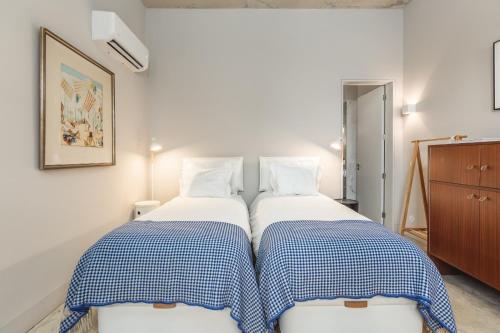 dwa łóżka siedzące obok siebie w pokoju w obiekcie Tanger Suite - Serralves, beach & Yayoi Kusama w Porto