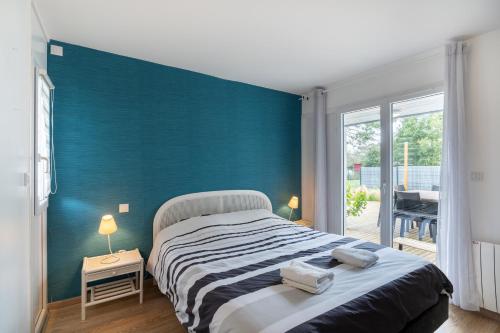1 dormitorio con 1 cama grande y pared azul en Ty Kermor, en Combrit