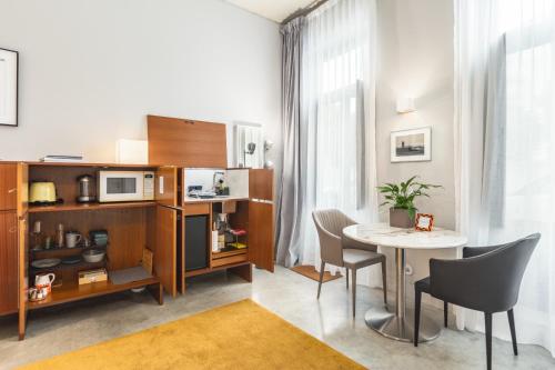 Habitación con mesa, sillas y microondas. en Tanger Suite - Foz, Serralves & beach, en Oporto