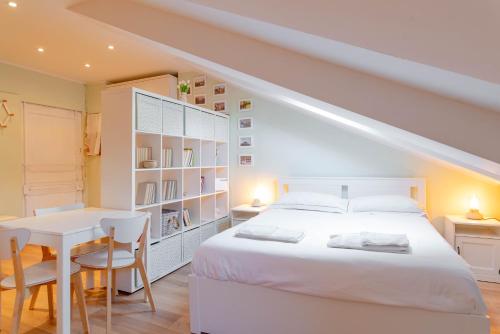 a bedroom with a white bed and a table and chairs at Nella casa del pittore in Turin