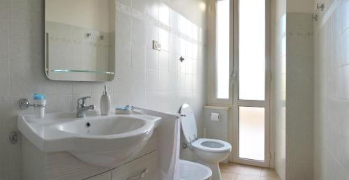 un bagno bianco con lavandino e WC di Dimora nel borgo a Offida