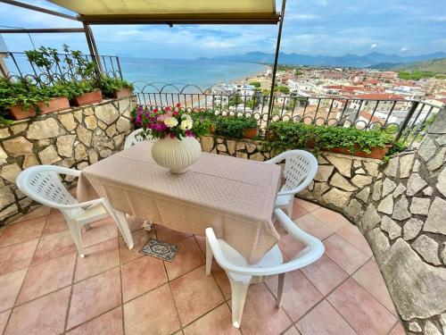 a table and chairs with a vase of flowers on it at Florenza Residence in Sperlonga