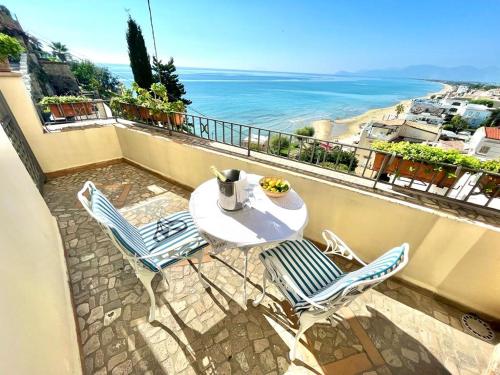 un tavolo e sedie su un balcone con vista sull'oceano di Florenza Residence a Sperlonga
