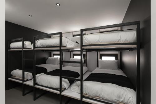 a room with three bunk beds with white pillows at Kip Hotel in London