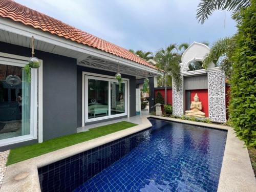 a house with a swimming pool in front of a house at VIEW TALAY VILLAs POOL 289, JOMTIEN BEACH, PATTAYA in Jomtien Beach