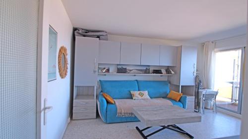 un salon avec un canapé bleu et une table dans l'établissement Le Grand Large, à Sainte-Maxime