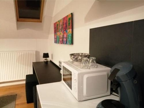 a microwave with wine glasses on top of it at The pop-art luxury suite in Charleroi