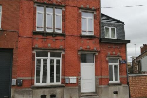 a red brick building with a white door and windows at The pop-art luxury suite in Charleroi