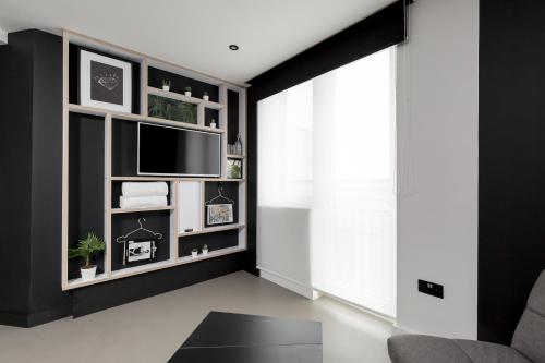 a living room with a tv and a black wall at Kip Hotel in London