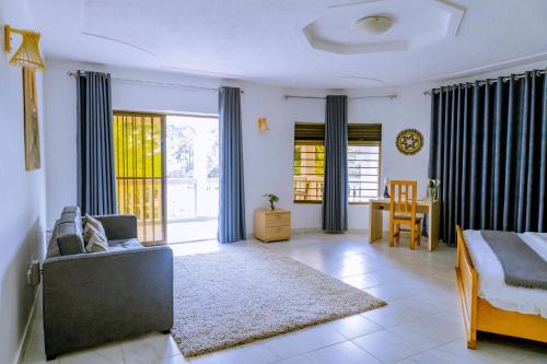 a bedroom with a bed and a couch and a table at Nature Kigali in Kigali