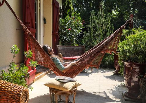 a man laying in a hammock on a porch at The Iflissen Pavilion - Luxury Villa in Lamorlaye