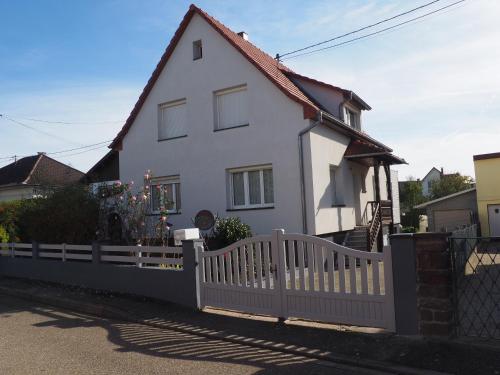 a white house with a white picket fence at Gîte du héron in La Wantzenau